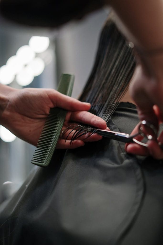 person-holding-black-hair-comb-3993447 Close-up of hairstylist cutting wet hair in a salon.